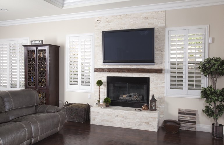 White plantation shutters in a Boston living room with solid hardwood floors.